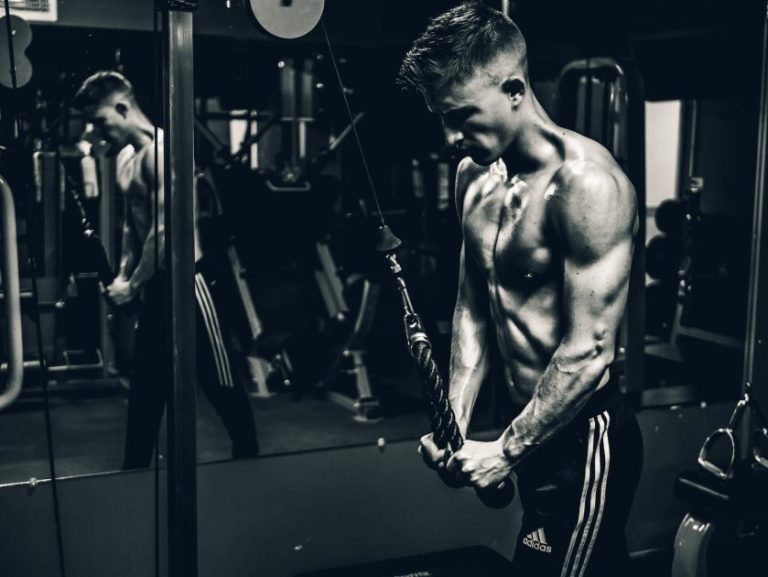 Persoon traint thuis met voordelen van thuis fitnessen zoals flexibiliteit en gemak in privéomgeving